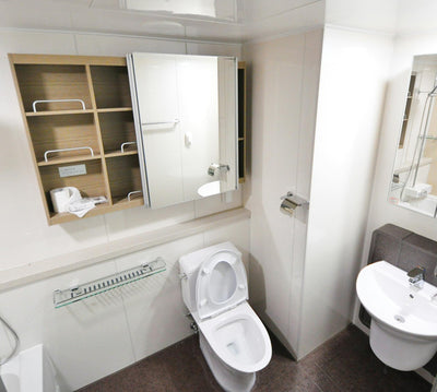 Small bathroom with toilet paper stored in an open cabinet (Photo by Pixabay from Pexels)
